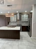 Contemporary kitchen featuring a large central island with an integrated sink and a white countertop - 