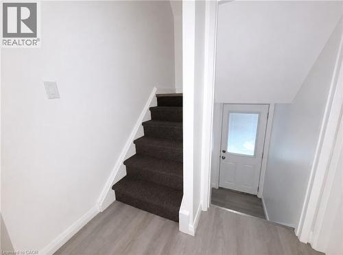 Carpeted staircase with white risers and white baseboards - 83 East 41St Street, Hamilton, ON - Indoor Photo Showing Other Room