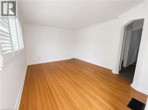 Spacious room featuring wood-finish flooring and white walls - 83 East 41St Street, Hamilton, ON - Indoor Photo Showing Other Room