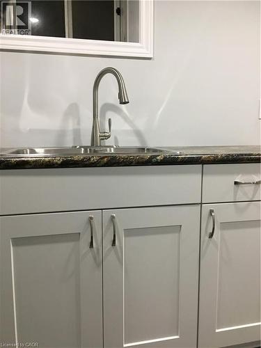 Kitchen sink featuring a dual basin, stainless steel faucet, and granite-finish countertop - 92 Pattandon Avenue Unit# C, Kitchener, ON - Indoor Photo Showing Kitchen