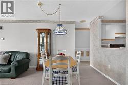 Dining area featuring a hanging pendant light, textured wallpaper, and carpeting - 