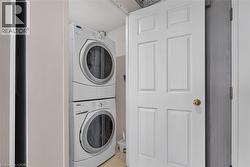 Dedicated laundry area featuring a stacked washer and dryer unit - 