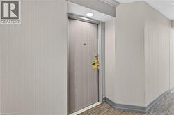 Entry door with brass hardware set within a cased opening, featuring recessed lighting and a crown molding detail - 