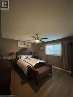 Room featuring wood-finish flooring, a ceiling fan with integrated lighting, and window blinds - 