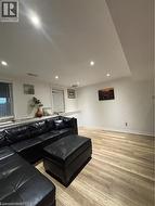 Recessed lighting illuminating a spacious room with wood-finish flooring - 