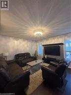 Living area featuring dark wood-finish flooring, light grey painted walls, and window blinds - 