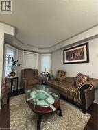 Living area featuring a bay window with multiple panes, dark wood-finish flooring, and a decorative ceiling detail - 