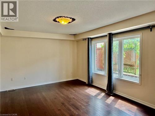 Spacious interior featuring wood-finish flooring, light-colored walls, and a large window unit providing ample natural light - 386 Apple Hill Crescent, Kitchener, ON 