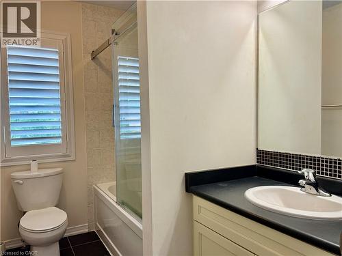 Bathroom featuring a vanity with an integrated sink, dark countertop, and mosaic tile backsplash - 386 Apple Hill Crescent, Kitchener, ON 