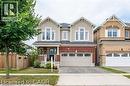 Two-story residence featuring a brick and siding facade, a two-car garage, and a covered front porch - 386 Apple Hill Crescent, Kitchener, ON 
