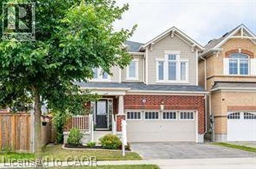 Two-story residence featuring a brick and siding exterior, front porch with white railing, and an attached two-car garage - 386 Apple Hill Crescent, Kitchener, ON 