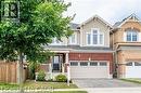 Two-story residence featuring a brick and siding exterior, front porch with white railing, and an attached two-car garage - 386 Apple Hill Crescent, Kitchener, ON 