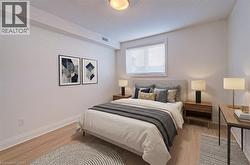Bedroom with light wood finished floors and a textured ceiling - 