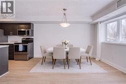 Dining room with light wood-type flooring and a textured ceiling - 