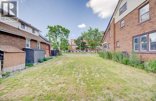 Expansive grassy yard area with brick exterior structures bordering each side - 153 Courtland Avenue E, Kitchener, ON 