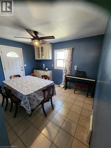 Spacious room featuring tile flooring, a window with natural light, and a ceiling fan with integrated lighting - 86 North Park Street, Brantford, ON 