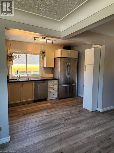 Kitchen area featuring wood-finish flooring, stainless steel appliances, and track lighting - 86 North Park Street, Brantford, ON 