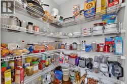 Walk-in pantry featuring white wire shelving units providing ample storage - 