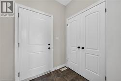 White paneled entry door with black hardware, complemented by a white bi-fold closet door with arched paneling and black knobs - 