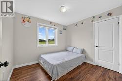 Room featuring wood-finish flooring, light neutral-toned walls, and a white trim package - 