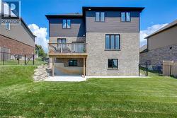 Two-story exterior featuring brick and horizontal siding, a raised wooden deck with railings, and a ground-level concrete patio - 
