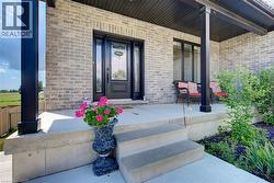 Front entry featuring a black paneled door with decorative glass inserts, framed by sidelight windows and a transom window - 