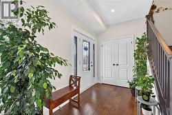 Entryway with wood-finish flooring and a white paneled entry door with decorative glass inserts - 