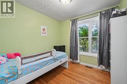 Bright room featuring wood-finish flooring, a double-hung window, and a flush mount ceiling light - 