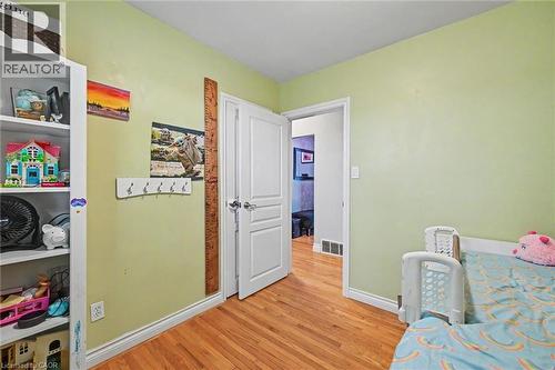 Wood-finish flooring throughout, complemented by light green wall finishes and white trim - 56 Everton Place, Hamilton, ON 