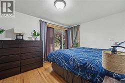 Light wood-finish flooring complements white walls and a ceiling-mounted flush light fixture - 