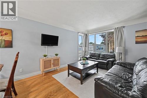 Living area with wood-finish flooring, light blue walls, and crown molding - 56 Everton Place, Hamilton, ON 