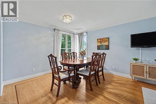 Hardwood flooring featuring an inlaid border, light blue wall paint, and white trim - 56 Everton Place, Hamilton, ON 