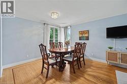 Hardwood flooring featuring an inlaid border, light blue wall paint, and white trim - 