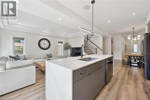 Open-concept living space featuring wood-finish flooring, recessed lighting, and a tray ceiling - 63 Plymouth Road, Kitchener, ON 