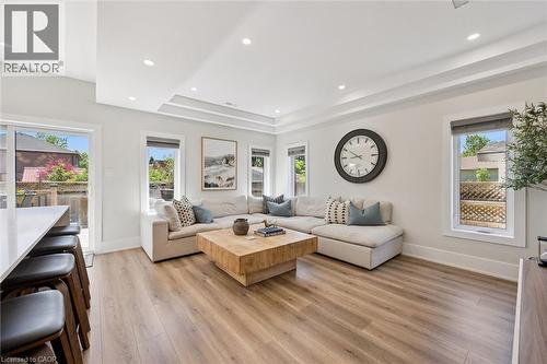 Open-concept living area with wood-finish flooring, recessed lighting, and a tray ceiling - 63 Plymouth Road, Kitchener, ON 
