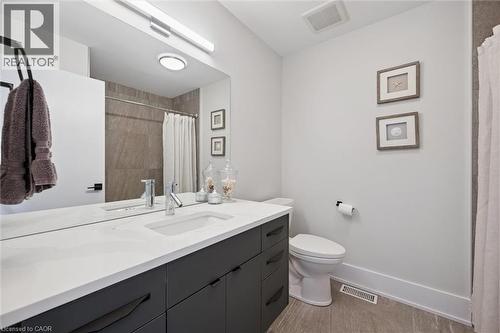 Bathroom featuring a spacious vanity with a white countertop and dark cabinetry - 63 Plymouth Road, Kitchener, ON 
