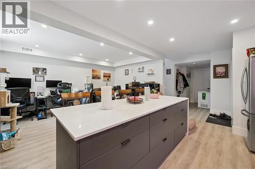Central kitchen island featuring a light-colored countertop and dark gray cabinetry with matte black hardware - 63 Plymouth Road, Kitchener, ON 