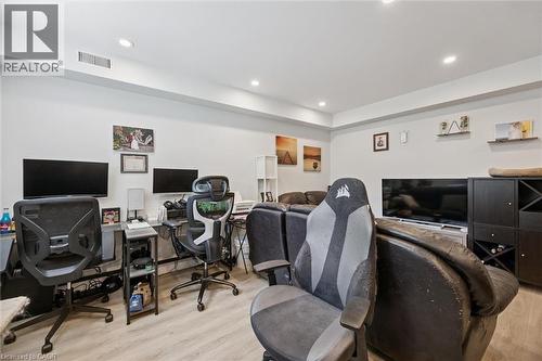 Recessed lighting illuminates this versatile space featuring light wood-finish flooring - 63 Plymouth Road, Kitchener, ON 