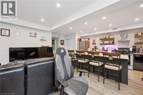 Open-concept living space featuring recessed lighting, light wood-finish flooring, and a kitchen island with seating - 63 Plymouth Road, Kitchener, ON 