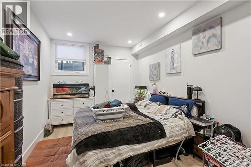 Recessed lighting illuminates this room featuring light wood-finish flooring, white baseboards, and a white interior door with black hardware - 63 Plymouth Road, Kitchener, ON 