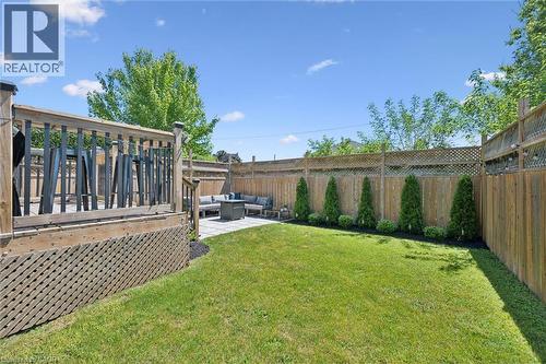 Expansive backyard featuring a lush lawn, privacy fencing, and a multi-level outdoor living space - 63 Plymouth Road, Kitchener, ON 