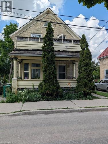 Brick facade with a gabled roofline, featuring an arched window and a second-story balcony - 15 Martin Street, Kitchener, ON 