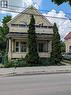 Brick facade with a gabled roofline, featuring an arched window and a second-story balcony - 15 Martin Street, Kitchener, ON 