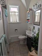 Bathroom featuring a white bathtub, toilet, and a vanity with an integrated sink - 