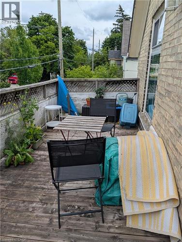 Exterior deck space featuring wood decking, a lattice privacy fence, and a brick wall - 15 Martin Street, Kitchener, ON 