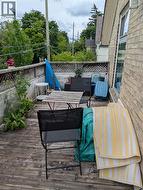 Exterior deck space featuring wood decking, a lattice privacy fence, and a brick wall - 