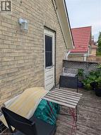 Outdoor wood-finish decking with a brick wall exterior - 