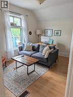 Bright room featuring wood-finish flooring, a window with natural light, and sloped ceiling details - 