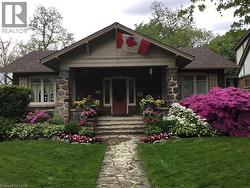 Craftsman-style home featuring a stone facade, covered front porch, and a flagstone pathway - 