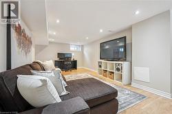 Living room with a desk, light wood finished floors, and recessed lighting - 